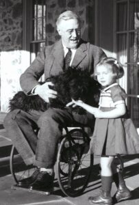 Bild von Franklin D. Roosvelt im Rollstuhl mit kleinem Kind